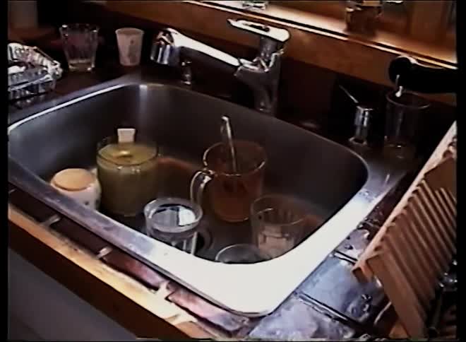 A middleaged man in the kitchen doing the dishes