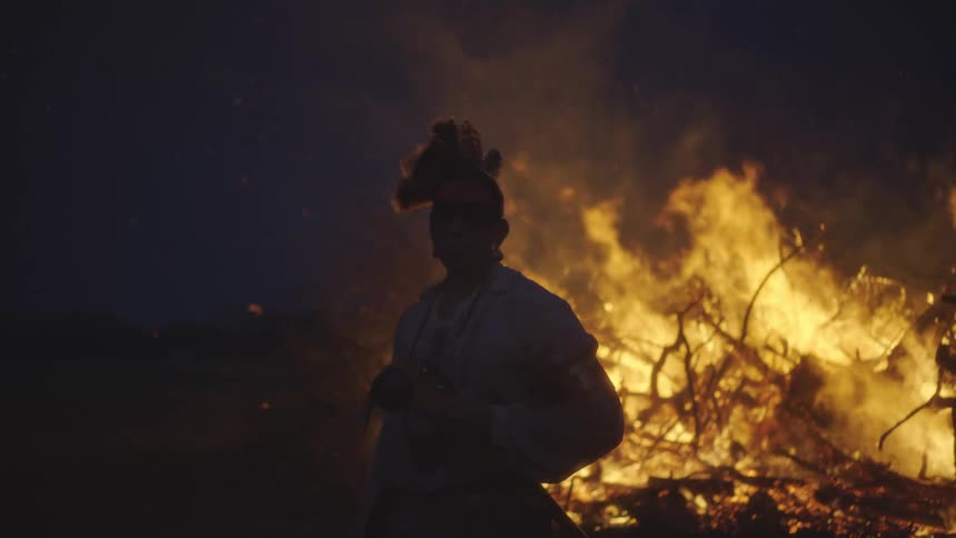 A person standing in front of a fire