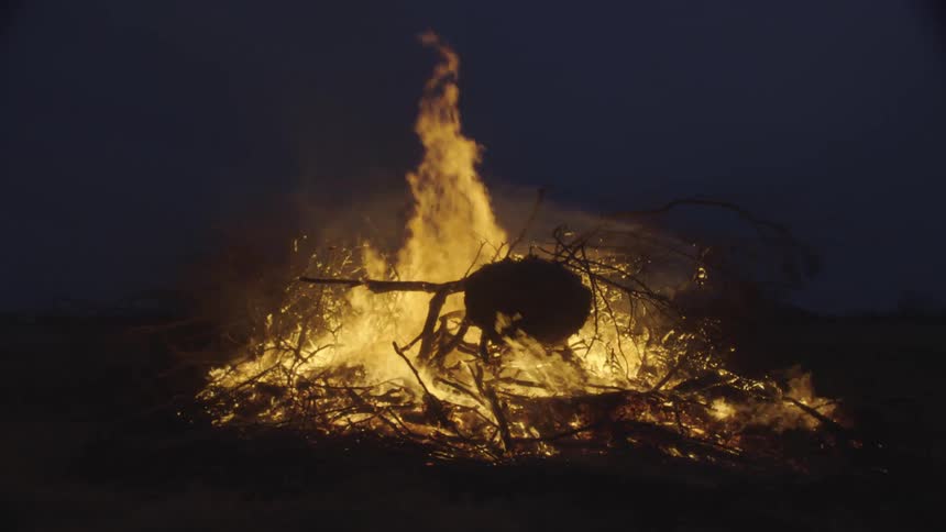 A fire burning outdoors at night