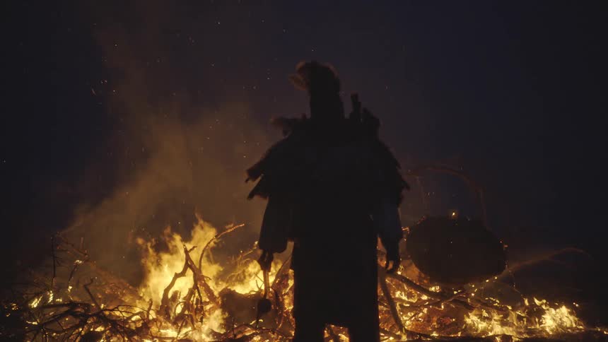 A man standing in front of a large fire