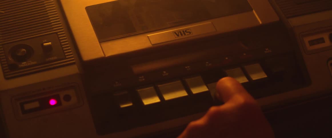 A finger pushes a button on a cassette player