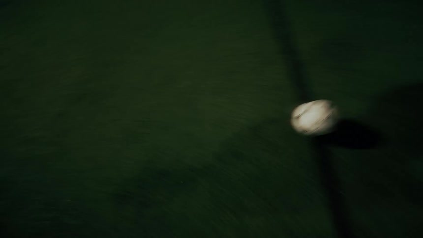 Two people playing a game of soccer at night