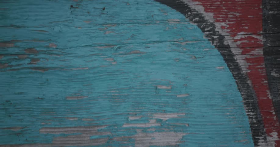 Detail of worn colorful paint on a wooden surface