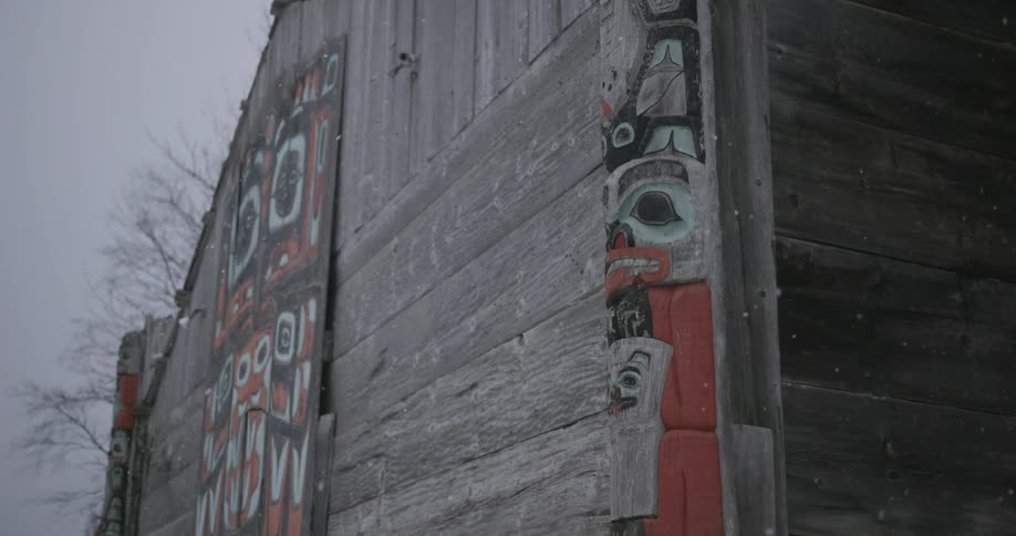 Art is a large flat panel featuring a symmetrical orange and black masklike facea carved totem pole integrated into the corner of the structure showing stacked figures with teal and red details