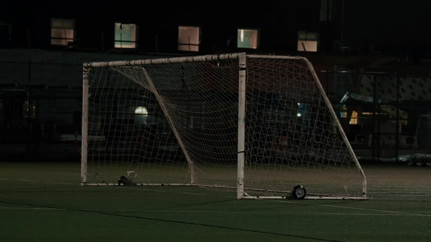 Empty soccer goal on a field at night
