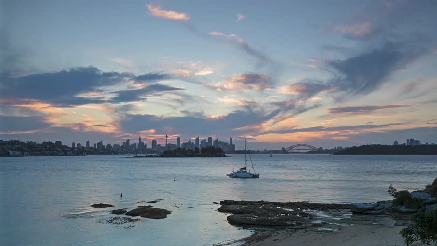 Day turning into night with a seascape and a metropolis in the background