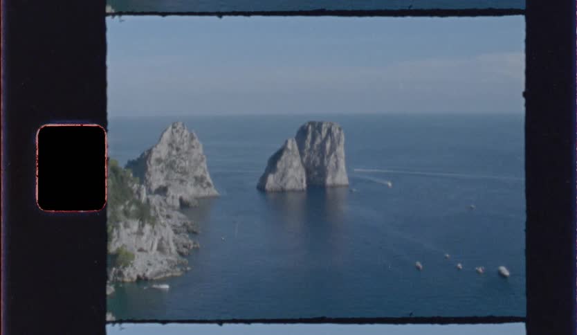 Rock formations rise from the blue sea near the coast