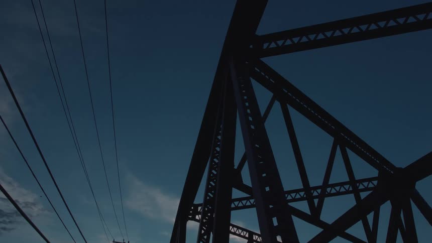 Metal bridge structure silhouetted against the blue sky at dusk