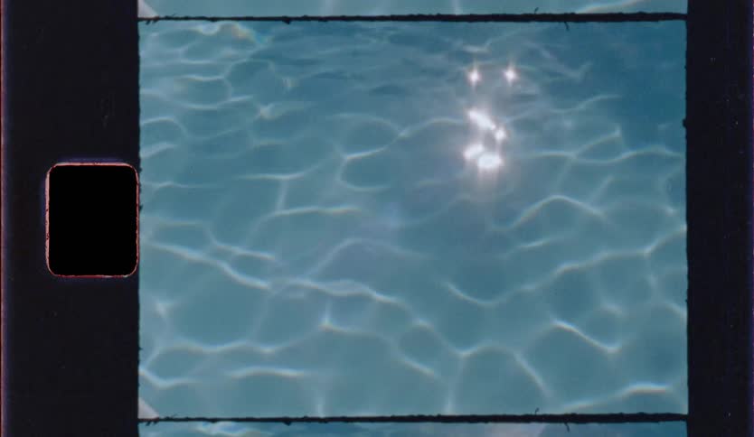 Bright sunlight glints off the surface of clear blue pool water creating shimmering reflections and rhythmic ripples across the frame in a nostalgic vintage film style