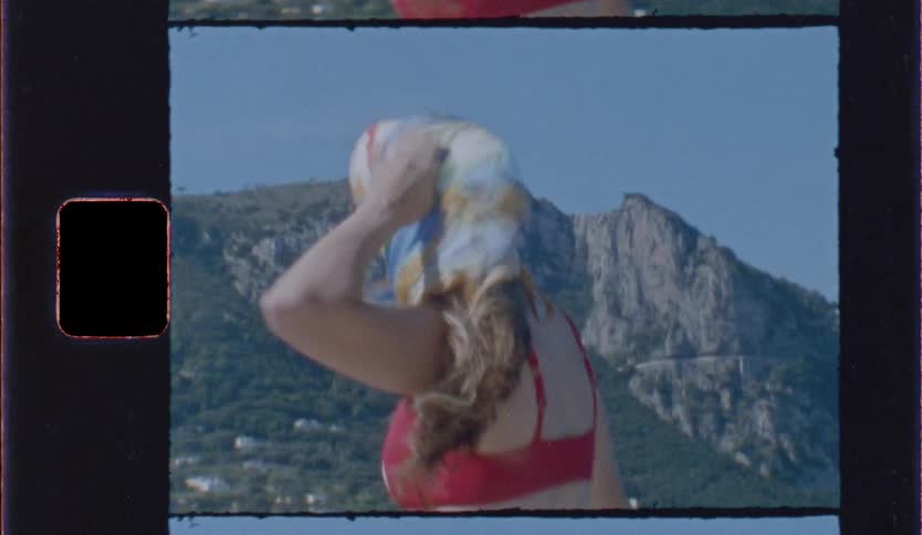 Woman in red bikini runs outdoors with mountains in the background