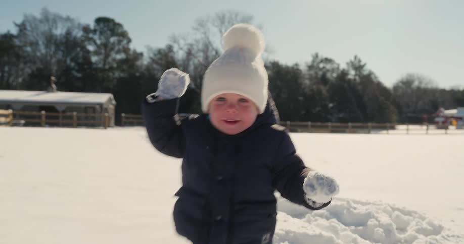 Smiling little child playing in the snow