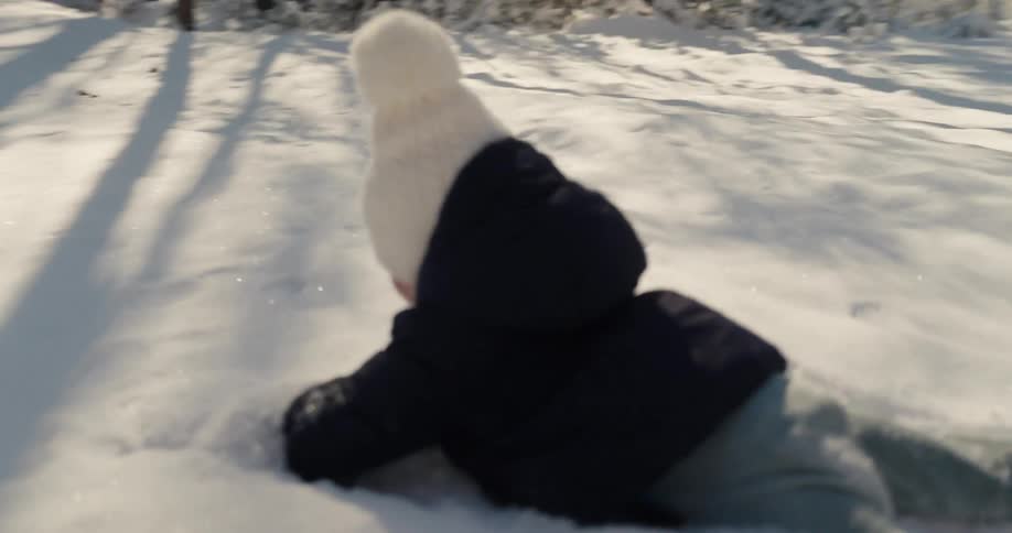 Child walks along a snowcovered trail in the forest