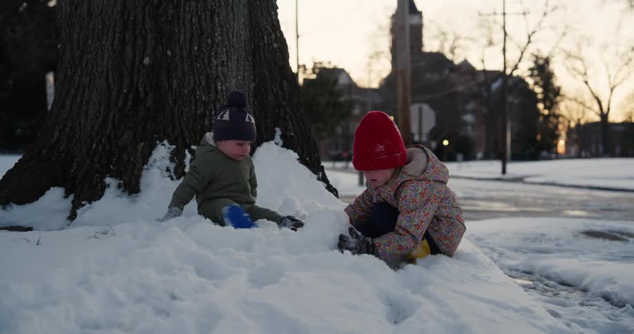 Two children playing outdoors in the snow