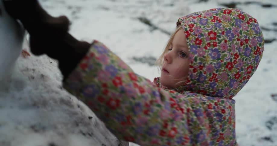 A child building a snowman outdoors