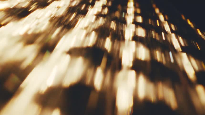 Textured surface shines golden in a dark area