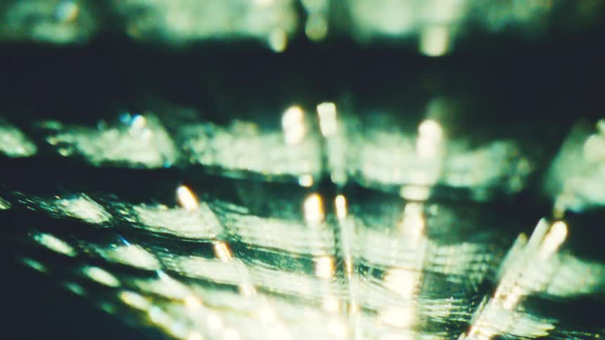 Blurred golden lights forming diagonal lines against a dark background