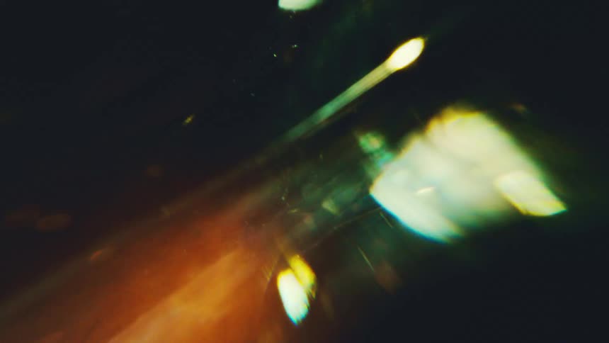 Abstract macro shot of light refracting through sharp glass prisms creating vibrant flares and glowing streaks