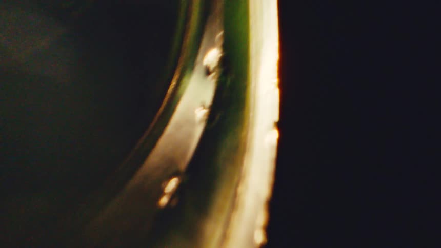 Curved streak of golden light crossing abstract shapes against a dark background