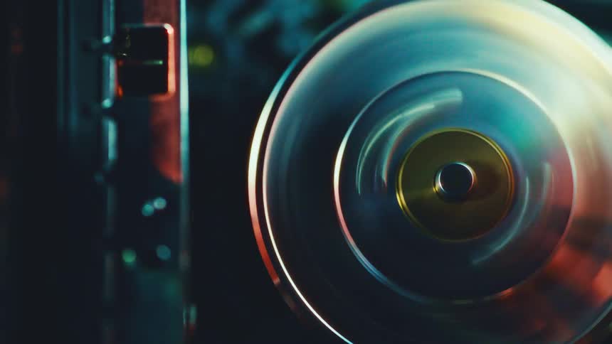 Metal disc spinning in industrial equipment under blue and yellow lighting