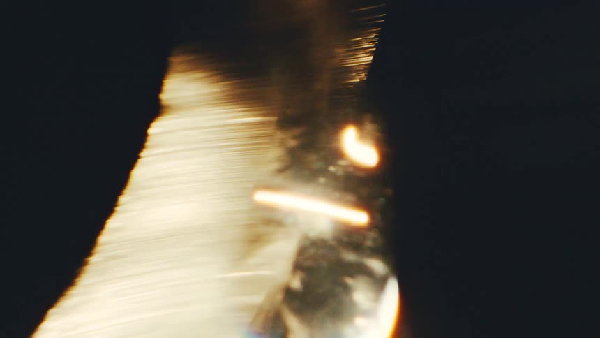 Intense golden light band with bright particles against a dark background