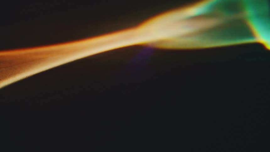 Wavy golden light streak crossing a dark background