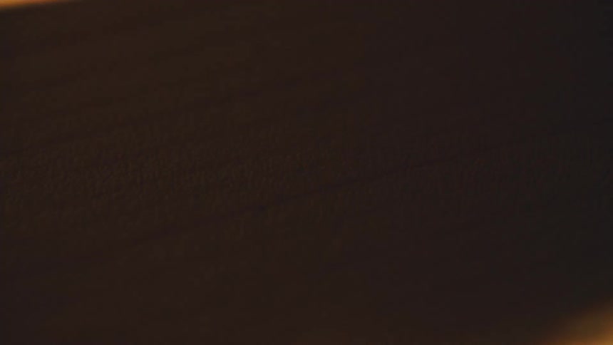 Wavy golden light streak crossing a dark background