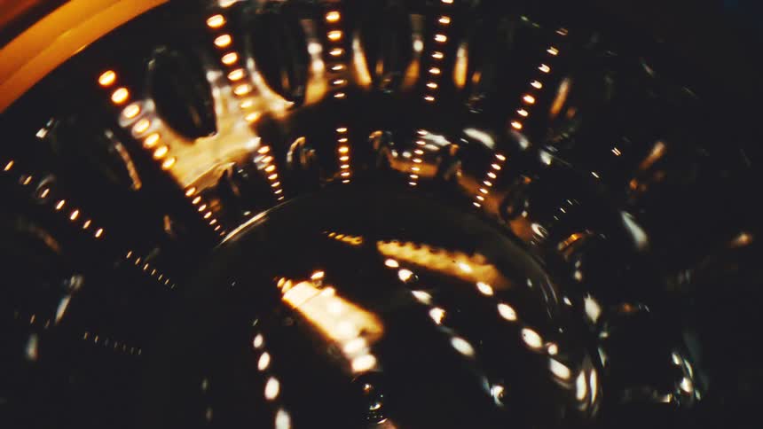 Inside a running dryer a bundle of clothes tumbles and flips in a steady circular motion fabrics sliding and folding over one another as the drum spins and soft light flickers across the moving pile