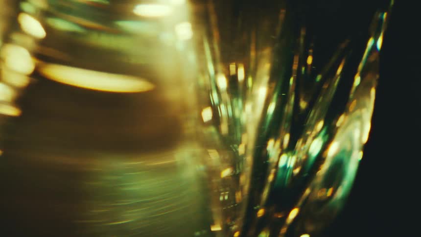 Elongated green and golden shapes reflecting light points in an abstract composition