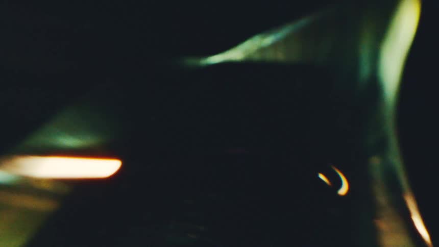 Green and golden abstract shapes with light beams against a dark background