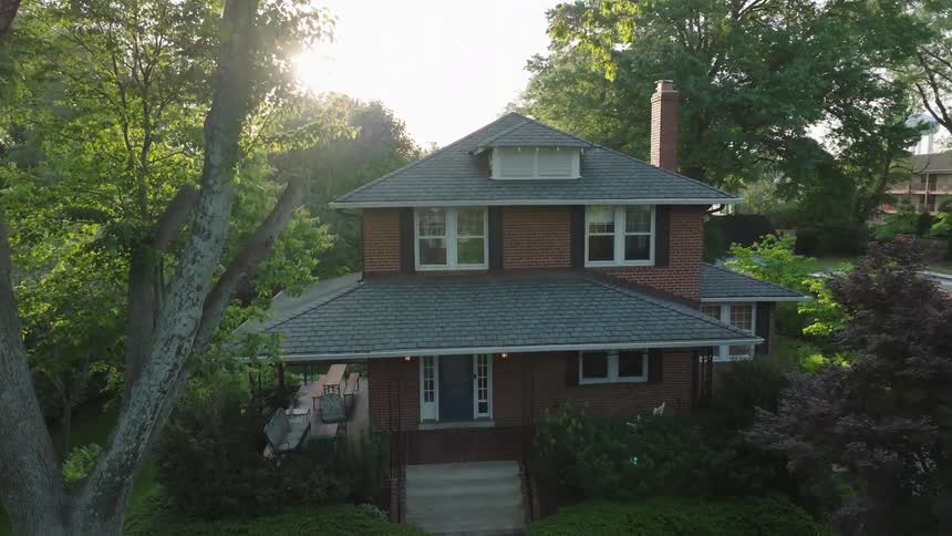 Two story house surrounded by trees in a suburban neighborhood outdoors during day time