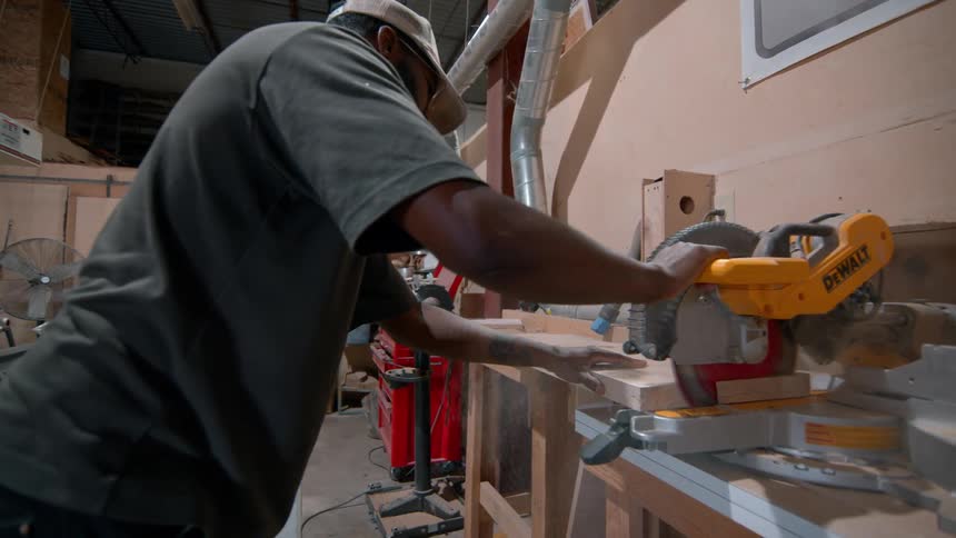 A man cutting wood in a shop