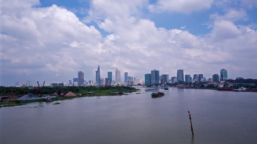 This timelapse video showcases a wide river bustling with boat traffic against the backdrop of a modern city skyline rapidly moving clouds and shifting sunlight highlight the energetic pace of this urban waterfront environment