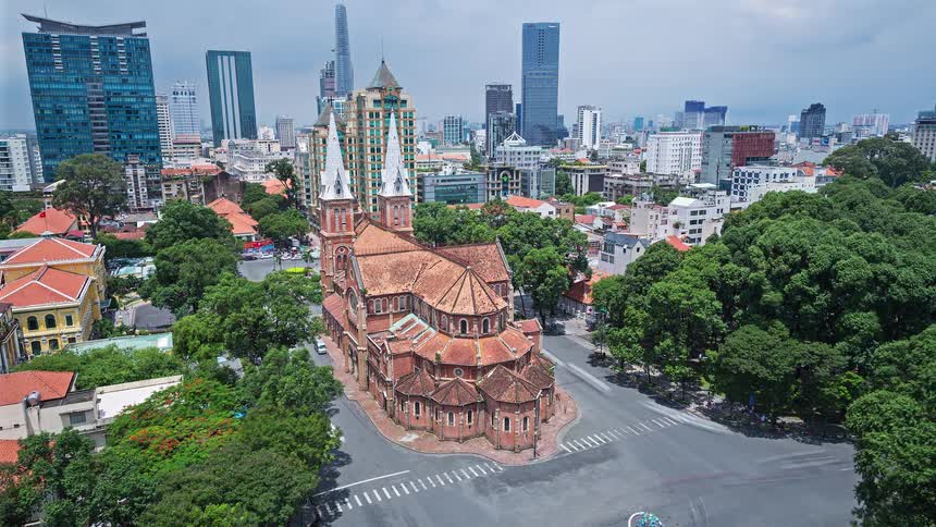 Aerial time lapse of saigon notre dame cathedral with traffic moving in urban cityscape background