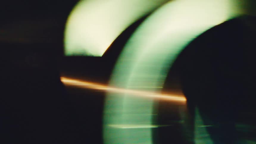 Blurred curved shapes with orange light streak over dark background
