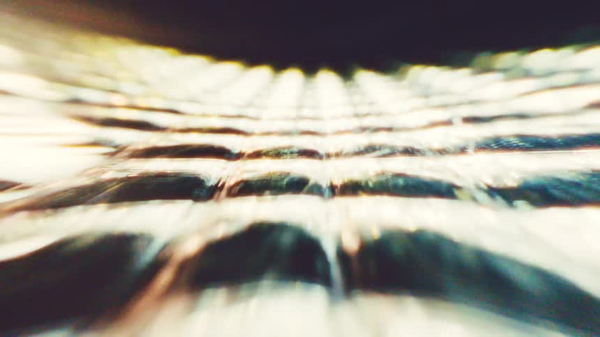 Blurred light lines forming geometric pattern in light and greenish tones