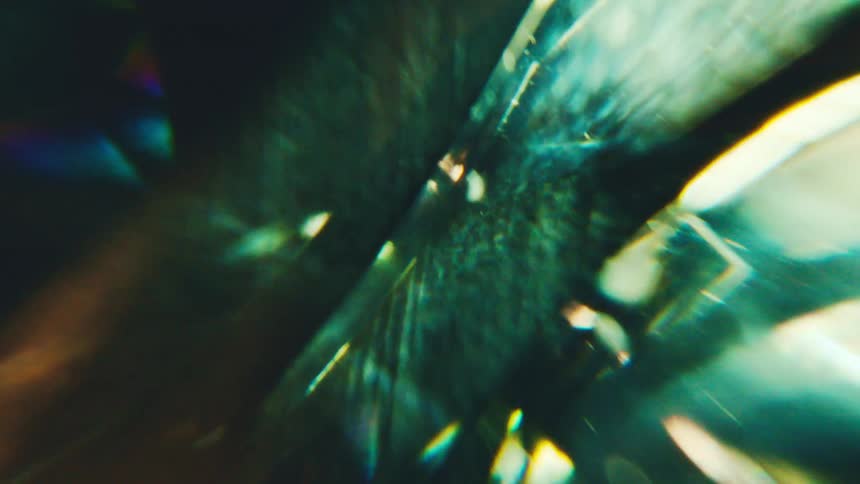 Abstract luminous reflections on translucent surface in green and bluish tones