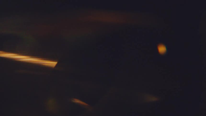 This video showcases a series of abstract and cinematic light leaks that transition across a dark background it features bright horizontal streaks of warm orange light and soft outoffocus green and yellow flares that create a dynamic sense of motion