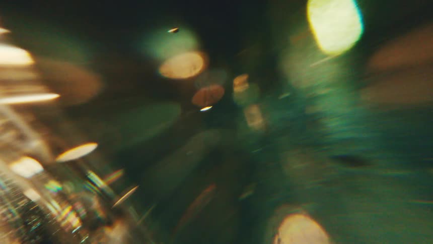 Translucent surface with reflections and distortions in golden and greenish tones