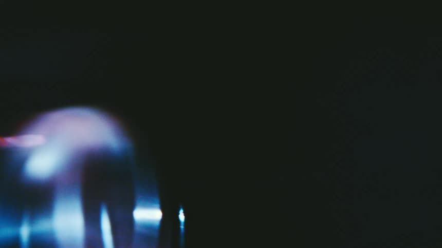 Blurred luminous shape in pinkish tone over dark background