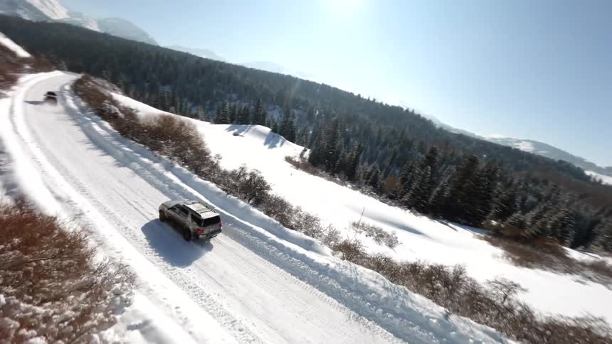 A car drives along a snowcovered freeway across the countryside on a winter day