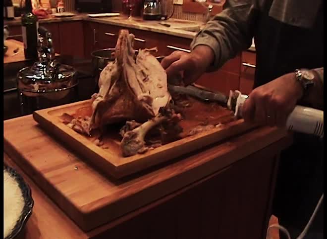 A man carving turkey in a kitchen