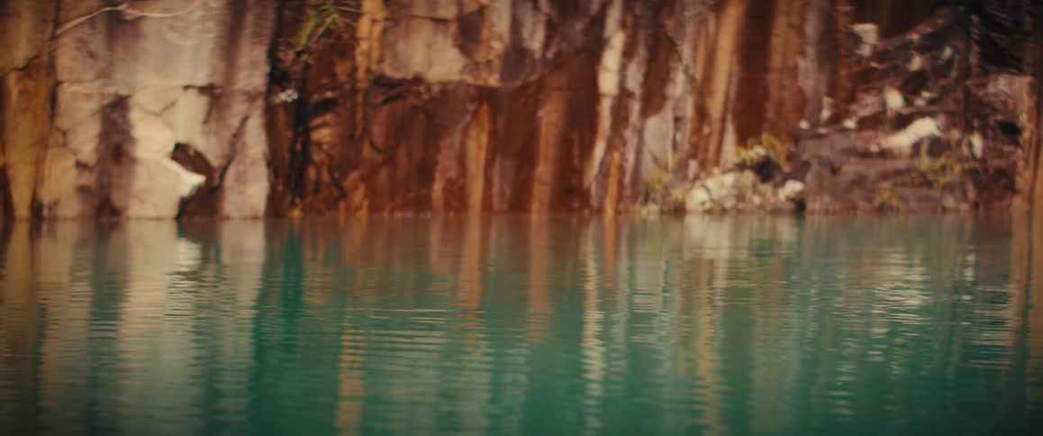 A small lake against some cliffs