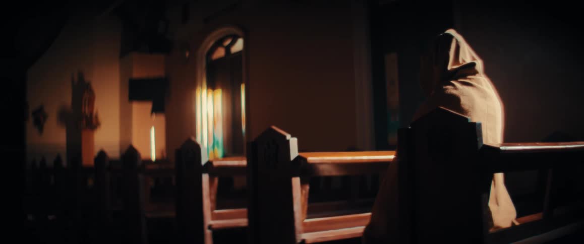 A person in a cloak sitting in a church