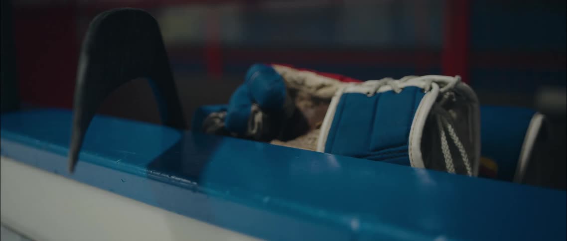 A close up of some hockey gloves and a hockey stick