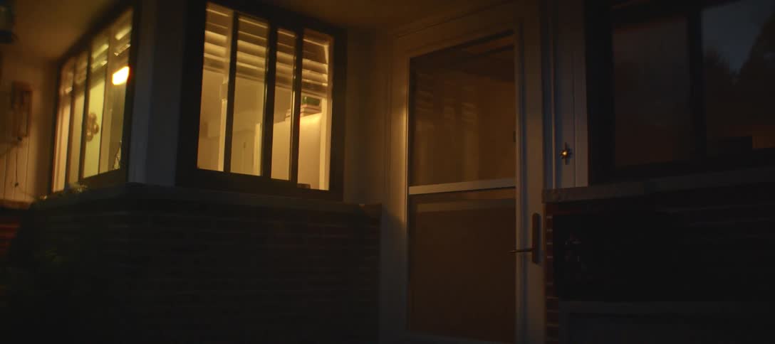 Lights glow inside house windows at night
