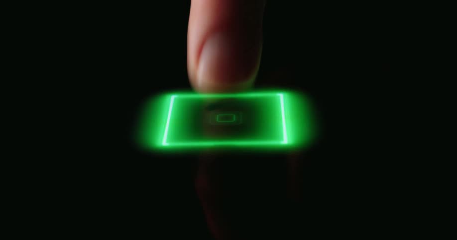 A finger presses down onto a dark surface triggering a glowing green square that illuminates upon contactas the pressure continues a complex network of neon green circuit board patterns radiates outward across the screen
