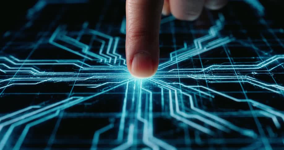 Index finger touches black surface activating glowing blue circuit board patterns in dark studio environment