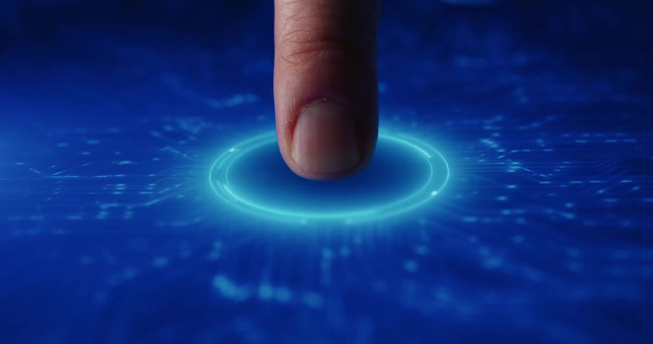 A man presses his fingertip onto a glowing blue circular button on a digital screen which activates a series of bright light patterns resembling electronic circuits