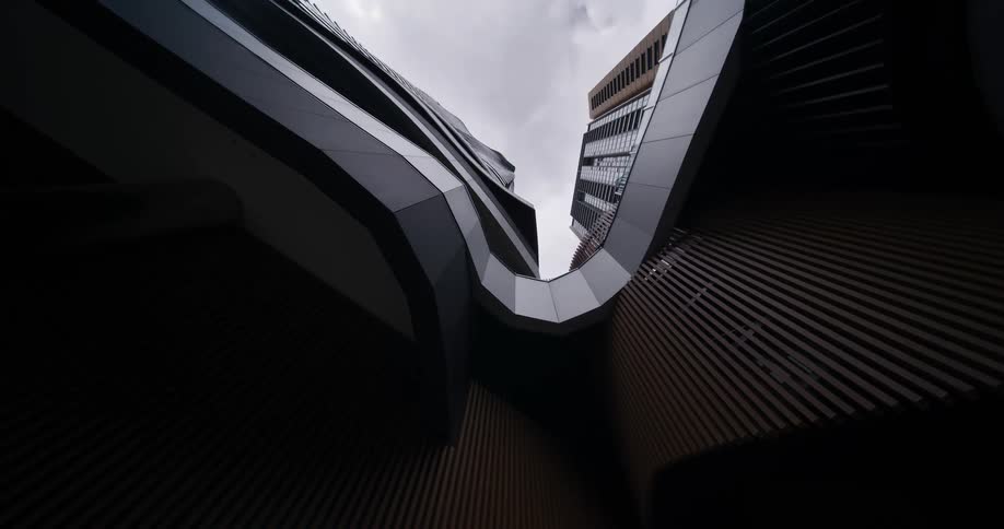 Modern buildings with curved facades and geometric lines seen from below
