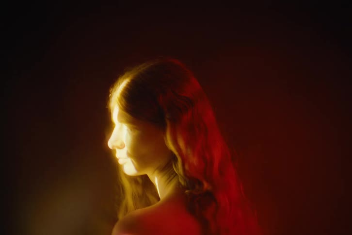 A portrait of a woman in a room with light on her face